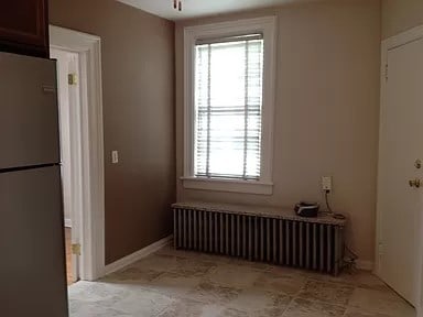 interior space featuring radiator heating unit and ceiling fan