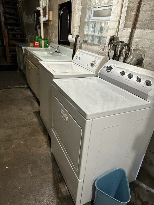 laundry area featuring separate washer and dryer, cabinets, and sink