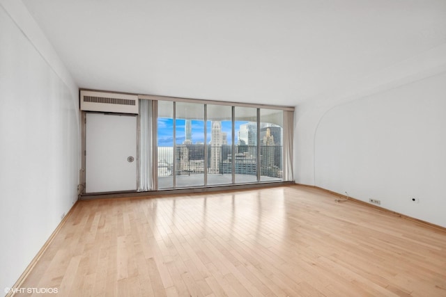 300 N State St Unit 4531, Chicago, IL 60654 - empty room with wood finished floors, a wall of windows, an AC wall unit, and a view of city