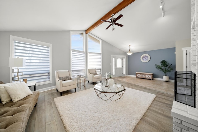 living room with vaulted ceiling with beams, light hardwood / wood-style flooring, and ceiling fan