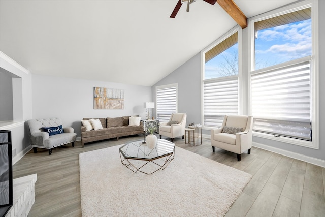 living room featuring beam ceiling, light hardwood / wood-style floors, high vaulted ceiling, and ceiling fan