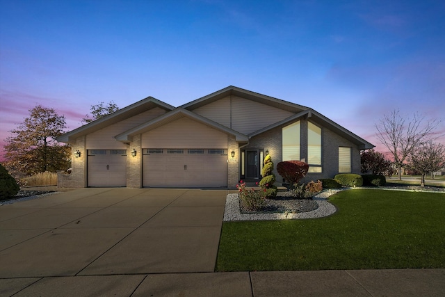 single story home featuring a lawn and a garage