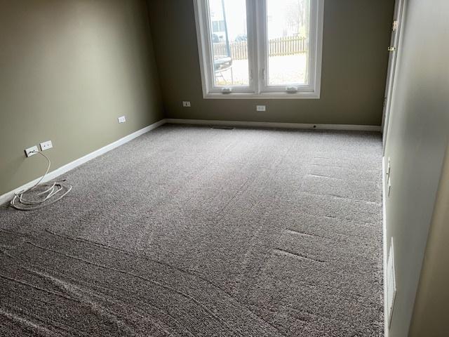 carpeted spare room with baseboards