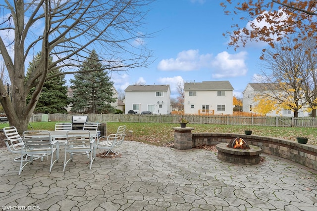 view of patio with outdoor dining space, a fenced backyard, and a fire pit