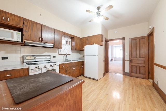 kitchen featuring sink, white appliances, ceiling fan, light hardwood / wood-style floors, and backsplash