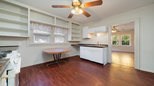 kitchen with dark wood-type flooring, white cabinetry, and white gas range oven