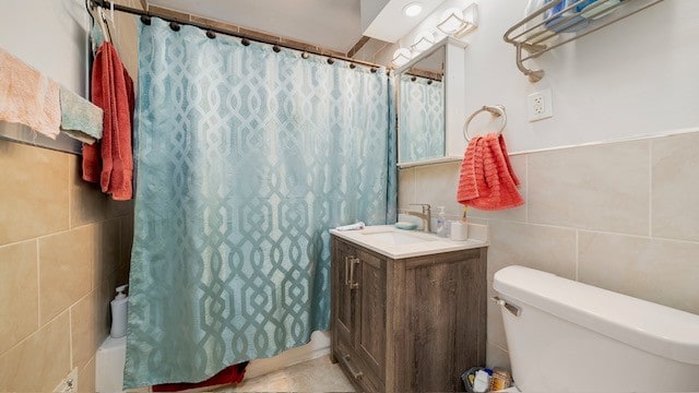 bathroom with tile walls, vanity, and toilet