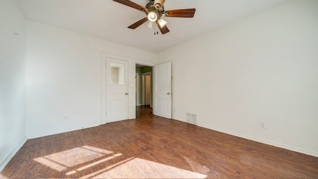 spare room with dark hardwood / wood-style flooring and ceiling fan