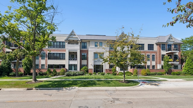 view of front of house with a front lawn and a balcony