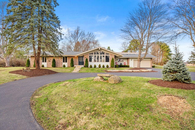 ranch-style house with a garage and a front yard