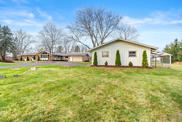 ranch-style house with a carport, a front yard, and a garage