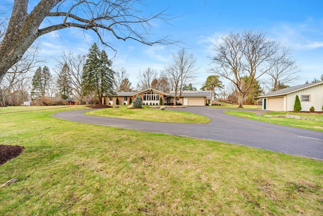 ranch-style house featuring a front yard and a garage