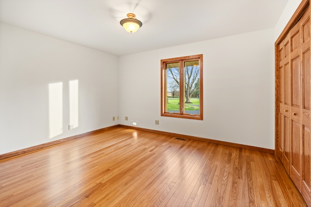 unfurnished bedroom with a closet and light wood-type flooring