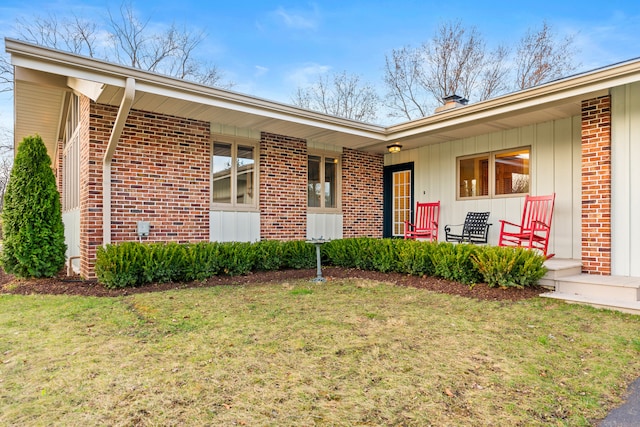 doorway to property featuring a lawn and covered porch