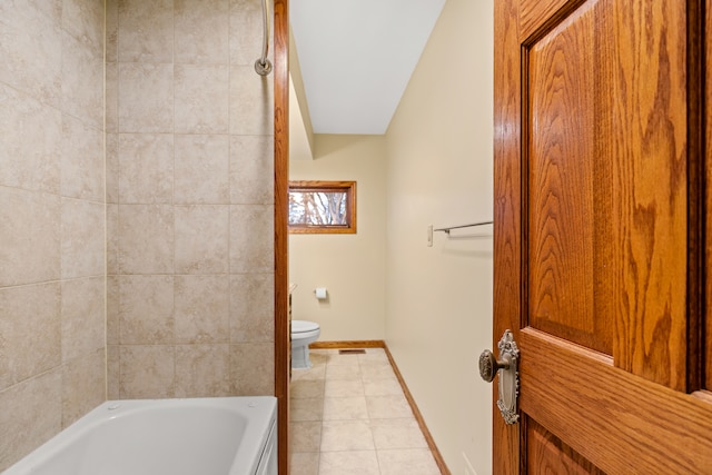 bathroom with toilet, tile patterned floors, and a bathing tub