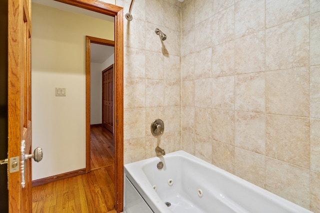 bathroom featuring wood-type flooring and tiled shower / bath