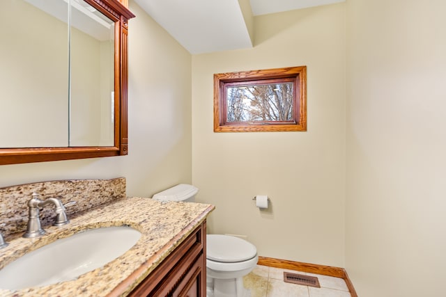 bathroom with toilet, vanity, and tile patterned floors