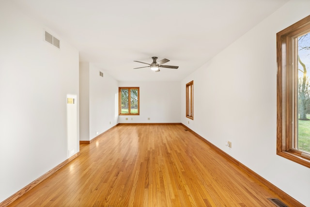 unfurnished room with light wood-type flooring, plenty of natural light, and ceiling fan