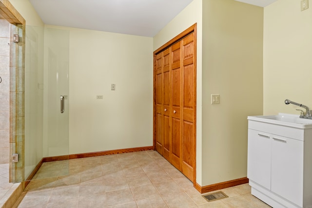 bathroom with tile patterned floors, vanity, and a shower with door