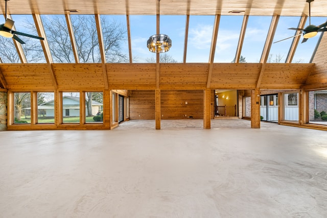 interior space featuring ceiling fan, concrete flooring, and high vaulted ceiling