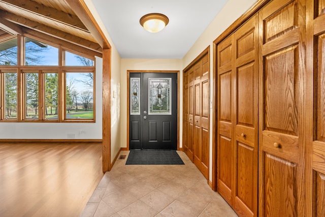 doorway with vaulted ceiling with beams and light hardwood / wood-style flooring