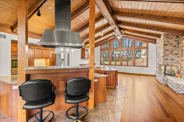 kitchen with a kitchen bar, stainless steel appliances, wooden ceiling, light hardwood / wood-style floors, and range hood