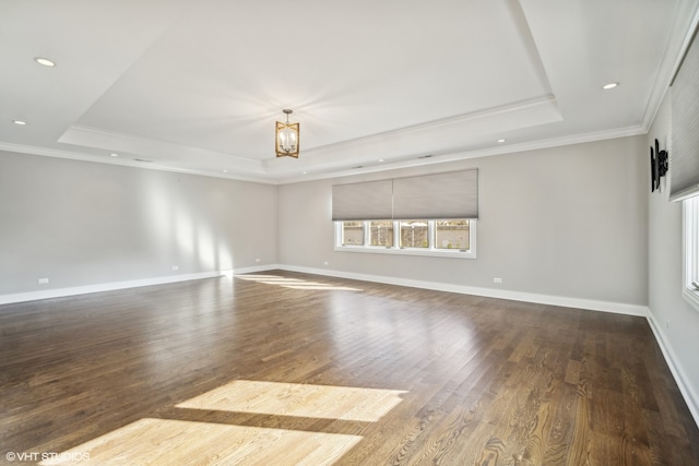 spare room featuring a tray ceiling, an inviting chandelier, hardwood / wood-style flooring, and ornamental molding