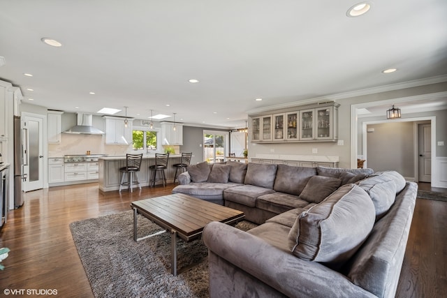 living room featuring a skylight, crown molding, and light hardwood / wood-style floors