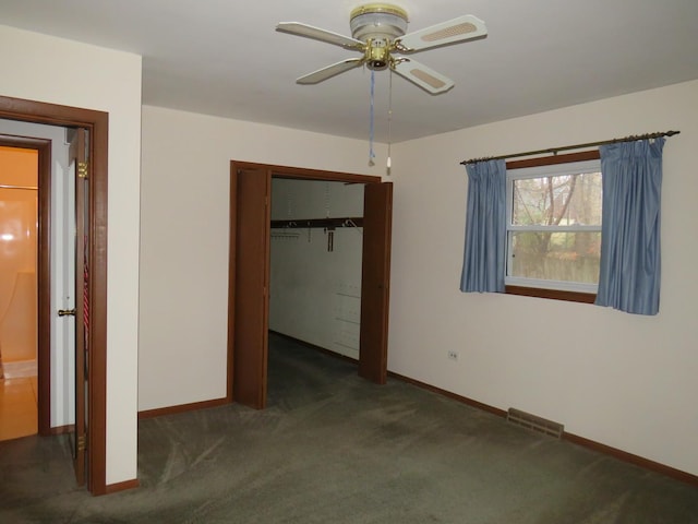 unfurnished bedroom with dark colored carpet, a closet, and ceiling fan