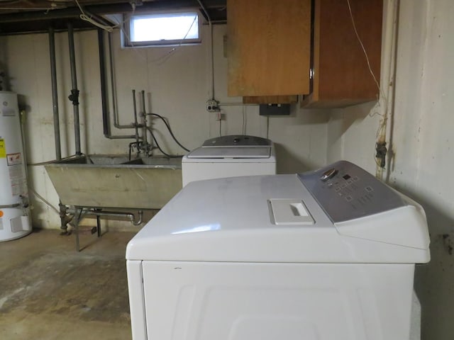 clothes washing area featuring washer and clothes dryer, cabinets, sink, and water heater