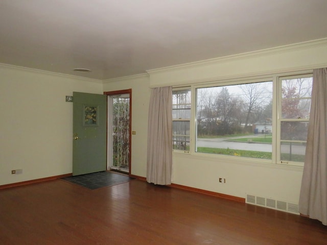 spare room with dark wood-type flooring, a water view, and a healthy amount of sunlight