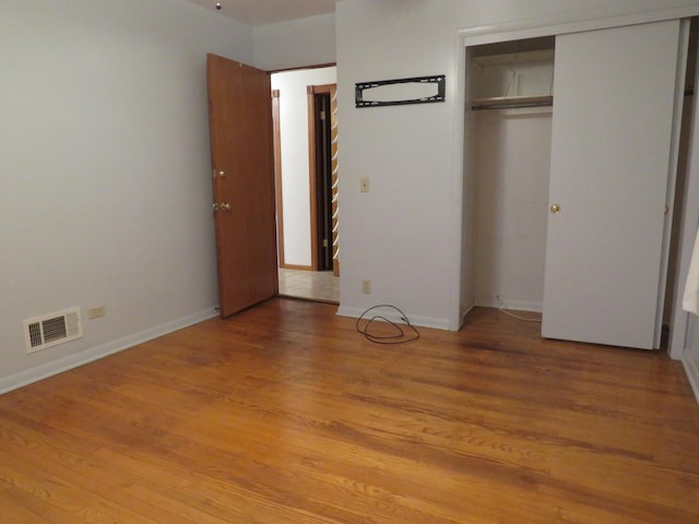 unfurnished bedroom featuring a closet and light hardwood / wood-style flooring