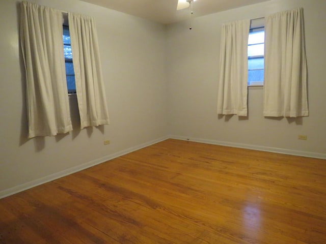 empty room with hardwood / wood-style floors and ceiling fan