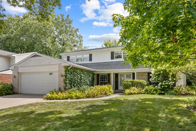 front of property with a garage and a front lawn