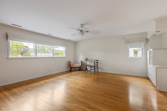 unfurnished room featuring light wood-type flooring, ceiling fan, and a healthy amount of sunlight