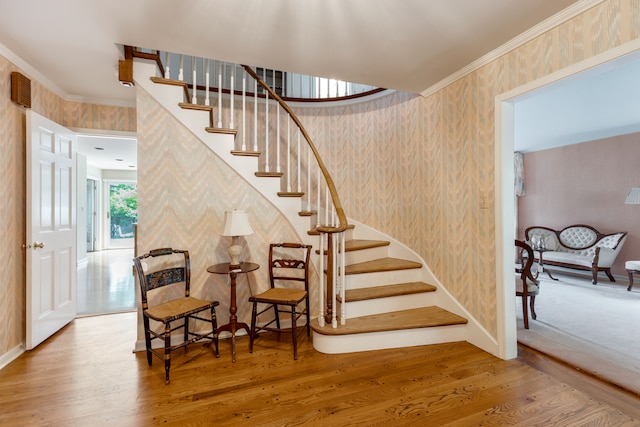 stairway featuring wood-type flooring and ornamental molding