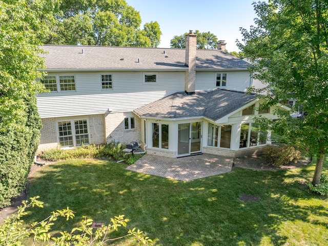 rear view of house featuring a sunroom, a patio, and a yard