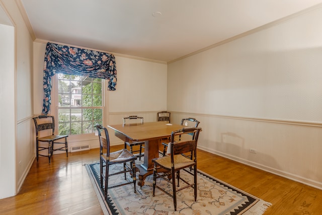 dining area featuring hardwood / wood-style flooring and ornamental molding