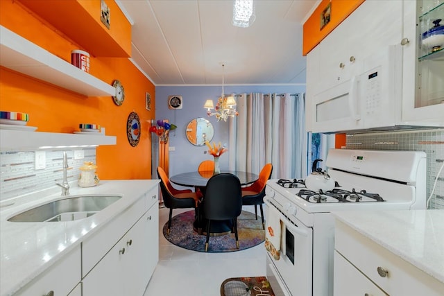 kitchen featuring sink, decorative light fixtures, white gas range oven, and white cabinets