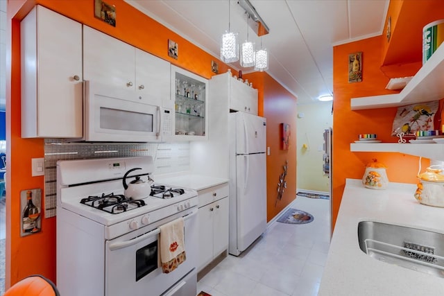 kitchen with decorative light fixtures, white appliances, crown molding, white cabinets, and decorative backsplash