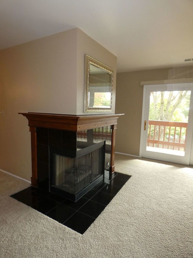 details with a tile fireplace and carpet flooring