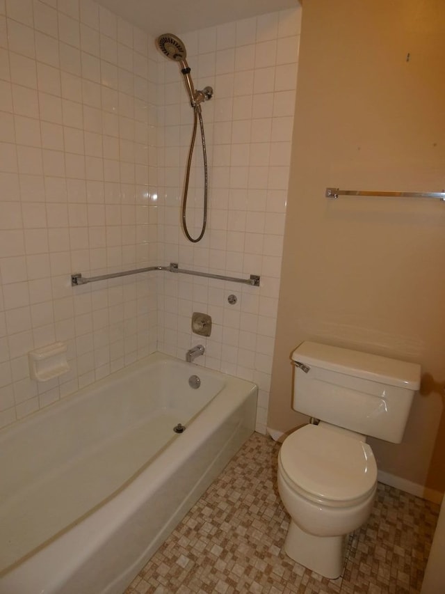 bathroom with toilet, tiled shower / bath combo, and tile patterned floors