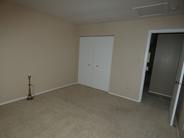 unfurnished bedroom featuring a closet and light colored carpet