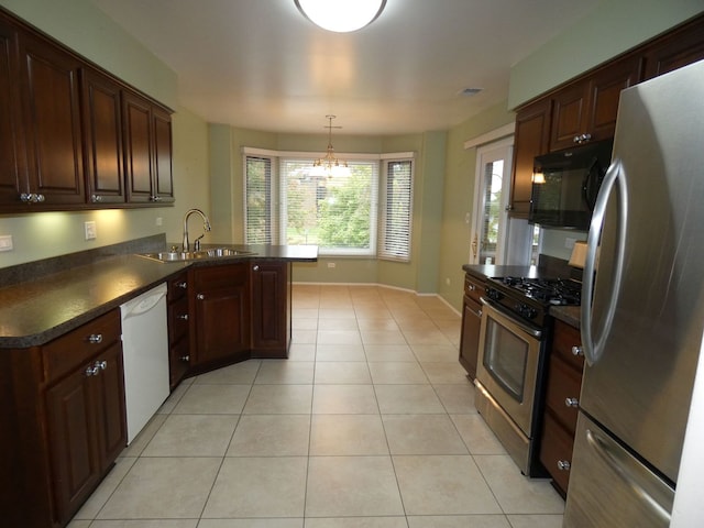 kitchen featuring sink, kitchen peninsula, appliances with stainless steel finishes, light tile patterned floors, and decorative light fixtures