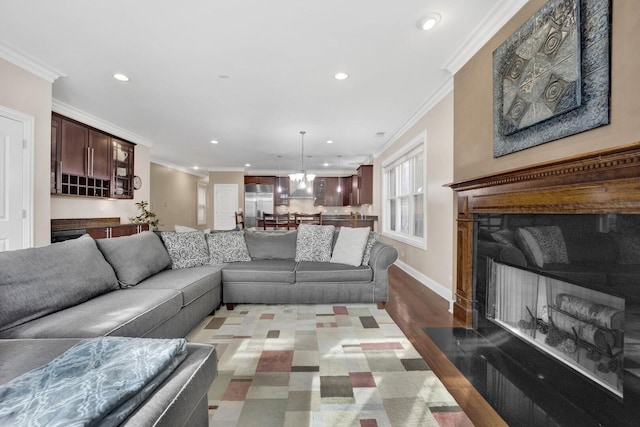 living room featuring baseboards, a fireplace with flush hearth, dark wood-type flooring, crown molding, and recessed lighting