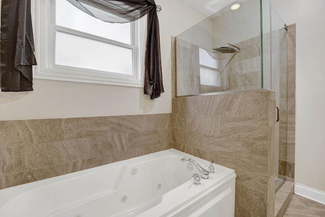 full bath featuring a jetted tub and a shower stall