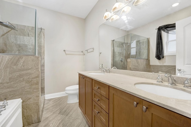 bathroom featuring double vanity, toilet, a walk in shower, and a sink