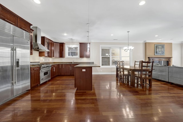 kitchen featuring crown molding, high end appliances, recessed lighting, dark wood-type flooring, and wall chimney exhaust hood