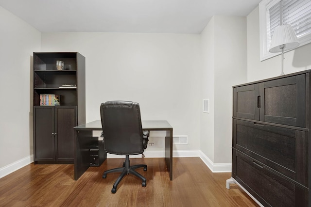 office space with visible vents, baseboards, and wood finished floors