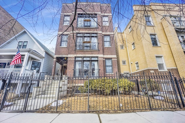 view of front of property featuring a fenced front yard and brick siding